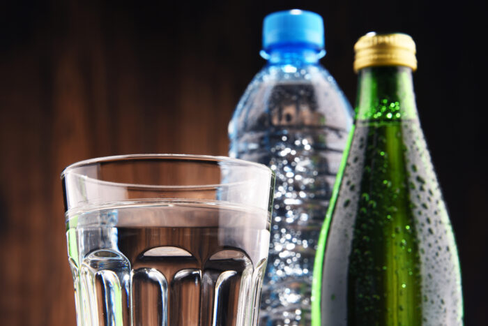 Composition with glass and bottles of mineral water