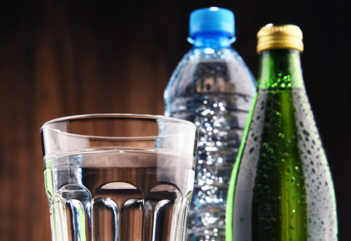 Composition with glass and bottles of mineral water